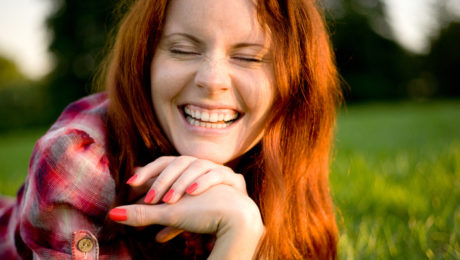 RedheadWomanWithRedNailsInGrass-850×400